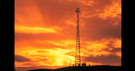 Photo of cellular tower silhoutted by sunset