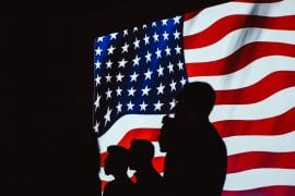 Sihouettes of people on US flag. Credit: Brett Sayles